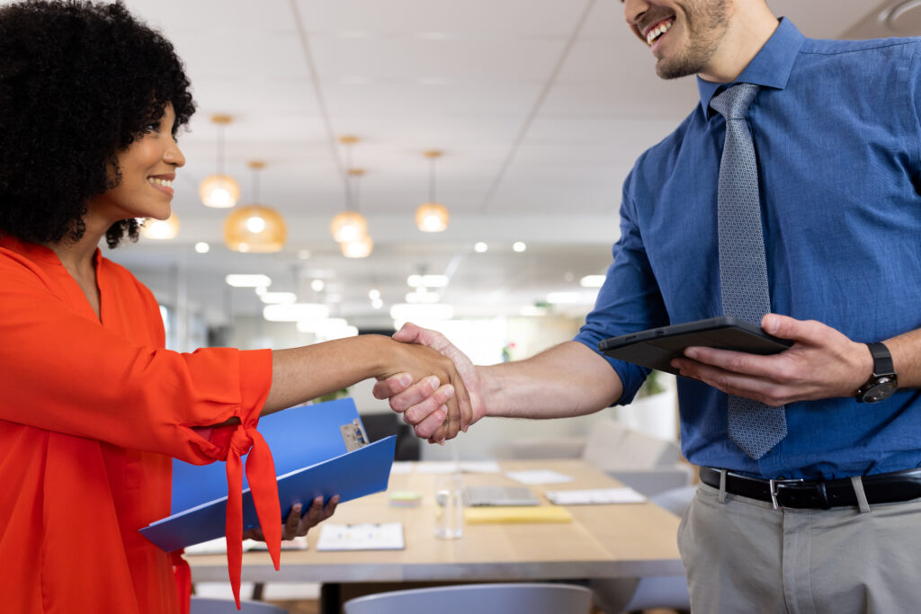 Two business professionals shaking hands in an office setting