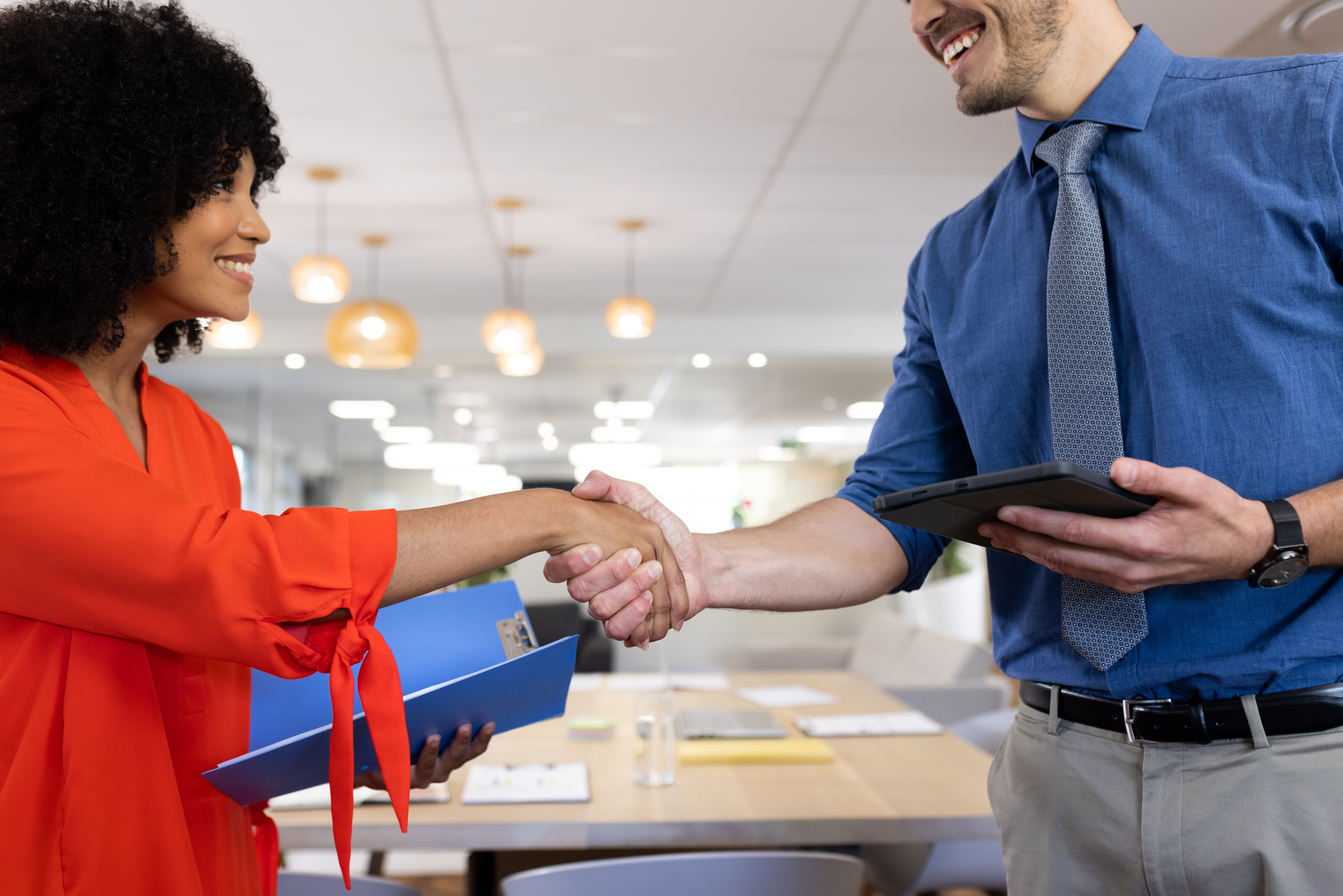 Two business professionals shaking hands in an office setting