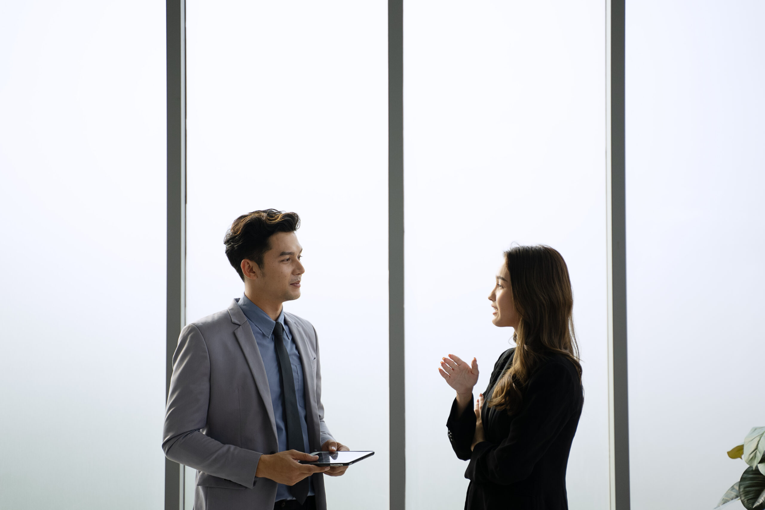 Two young professionals talking in a minimalist office setting